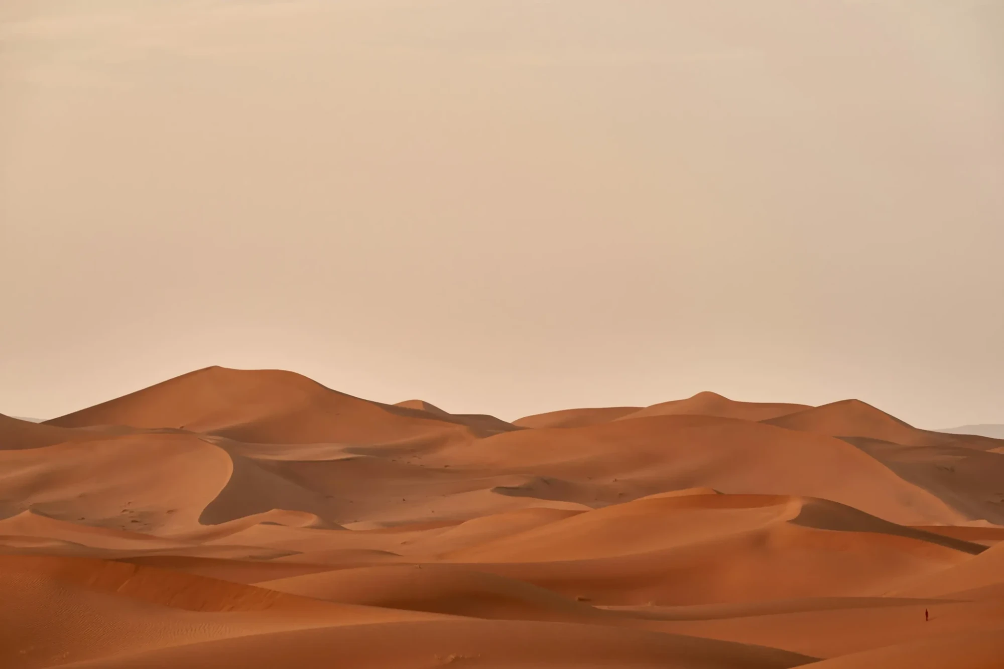 Rozľahlé piesočné duny na púšti Sahara počas západu slnka v Maroku.
